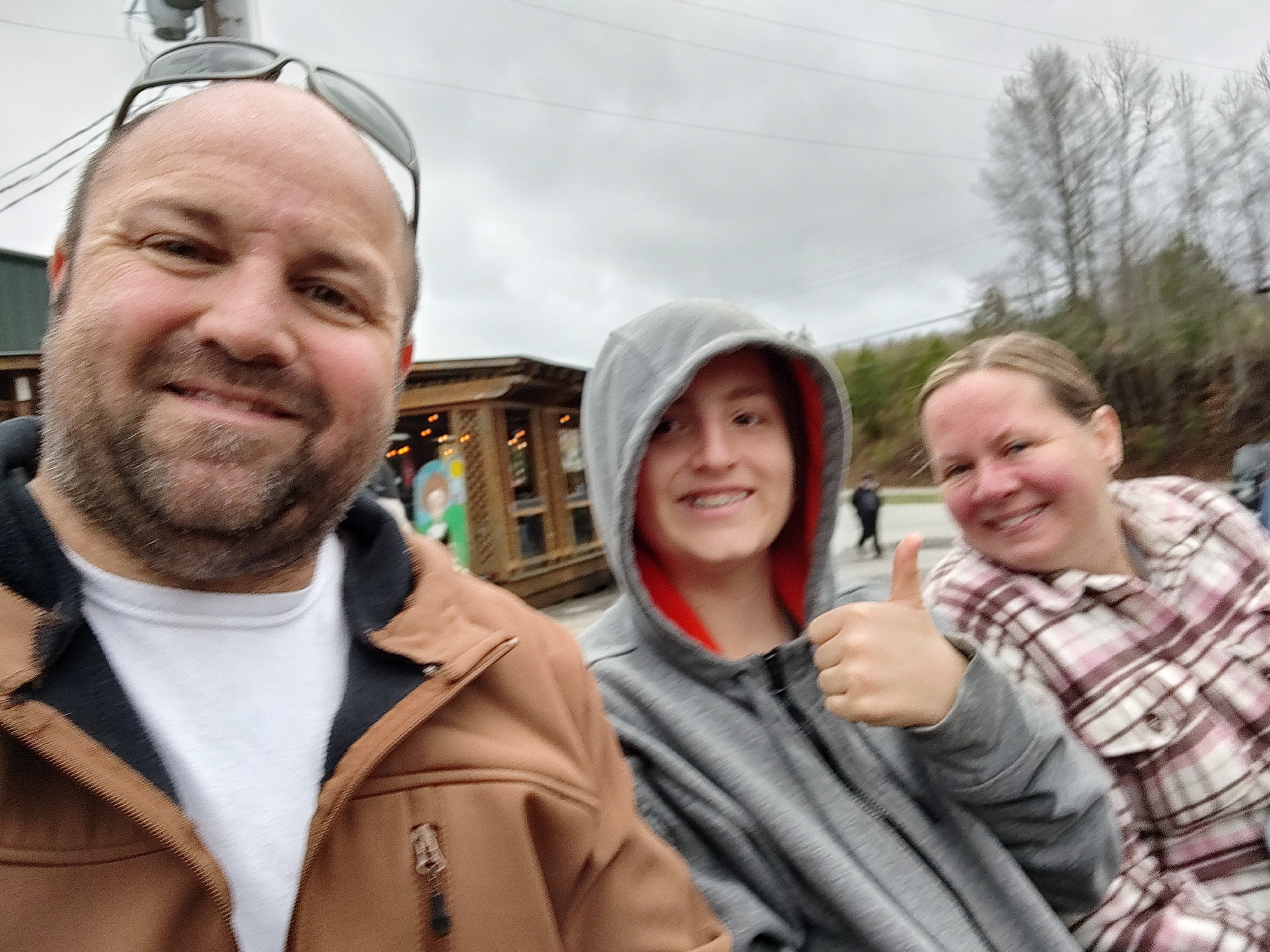 Family giving a thumbs-up during a tractor farm tour at Mercier Orchards.